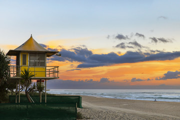 Lifeguard at sunrise on Gold Coast Surfers Paradise beach, with person sitting on the beach.