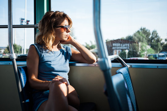 Young woman riding a public bus on a sunny day