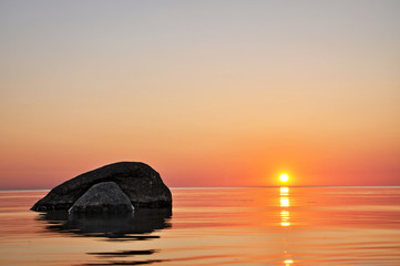 Fototapeta na wymiar Large stones in the sea at sunset.