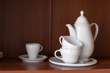 Tableware.   White porcelain tableware for coffee in the kitchen shelf.