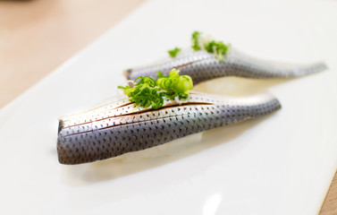 Kohada sushi, fresh spotted sardine and japanese rice on white plate