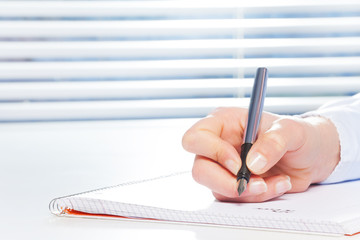 Hand writing with fountain pen at the table