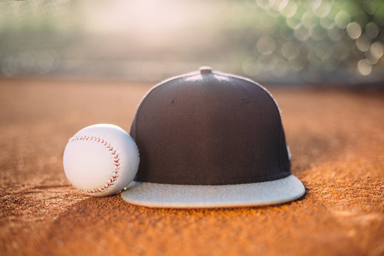 Baseball cap and ball on pitcher's mound