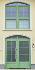 Grüne Haustür mit Glas und einem grünen Fenster
