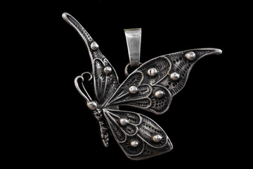 Old pendant in butterfly shape isolated on black