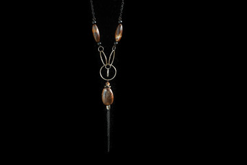 Old necklace with brown stones isolated on black