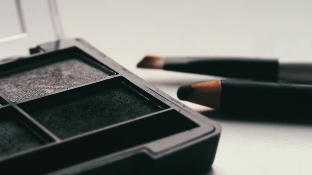 Gray shades of eyeshadow,Close up of makeup brush moving over eye shadows