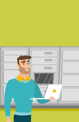 Engineer working on laptop in network server room.