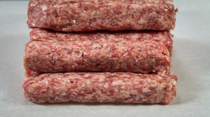 Raw kebab minced meat on white paper for grilling