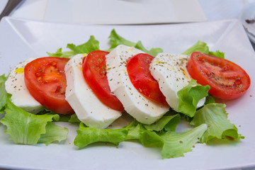 Salad Caprese, a combination of tomatoes, mozzarella and basil, is similar to the Italian flag selective focus