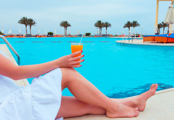 The woman enjoying cocktail in a swimming pool