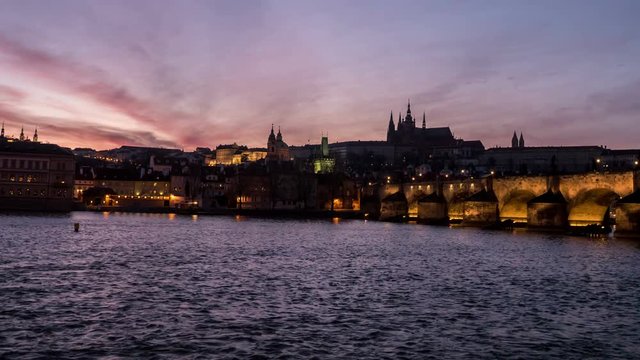 Amazing day-to- night transition view on the Charles bridge on the Vltava river,   impressive riverscape and skyscape, in the early spring in a sunny daytime, being taken as a time lapse  shot