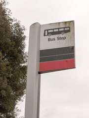 a bus stop sign with a bus vector icon white and black and red