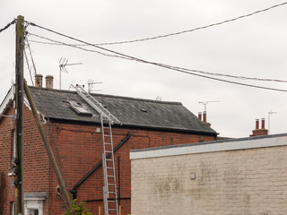 a ladder up the side of a house and along the roof construction no people or workers