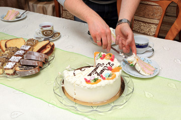 Obraz na płótnie Canvas Piękny tort urodzinowy, mężczyzna kroi tort.