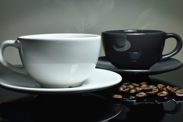 White and black Coffee cup, coffee beans on black table,  Focus white cup.