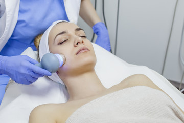 Fototapeta na wymiar Face skin care. Woman getting facial laser treatment