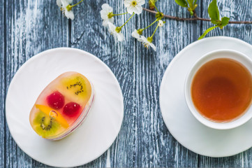 Still life with cup of tea and cake on the wooden background