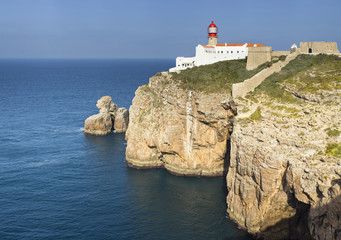 Fototapeta na wymiar yellow rocks in ocean and lighthouse