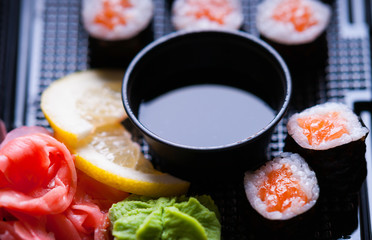 Sushi rolls with salmon, soy sauce, wasabi and ginger