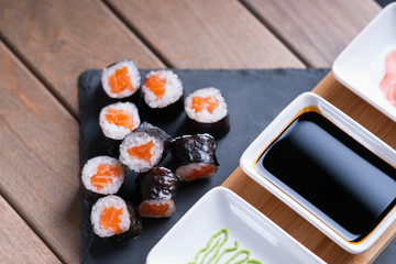 Sushi rolls with salmon and dishes with soy sauce, wasabi and ginger 