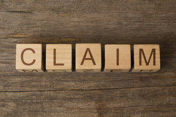 word claim written on wooden cubes on wooden background