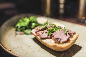 A sandwich with red fish and greens