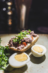 A sandwich with red fish and greens 2