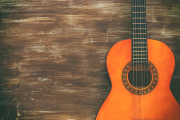 Close up of acoustic guitar against a wooden background