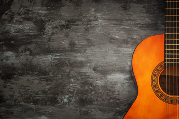 Close up of acoustic guitar against a wooden background