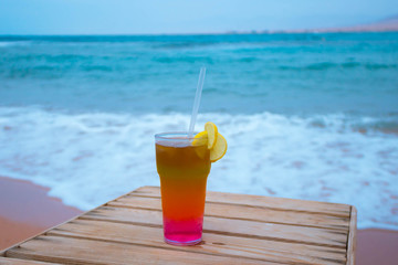 The cocktail with blur beach on background