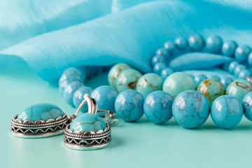 Strings of turquoise beads on blue silk as a background