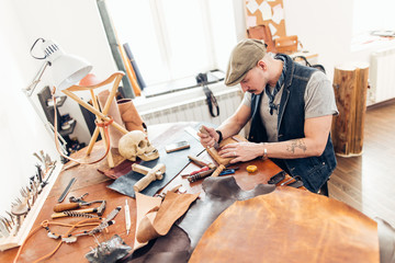Man working with leather using crafting DIY tools