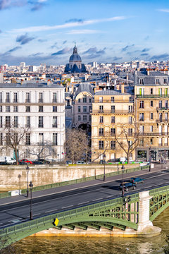 Paris view of green bridge over the Seine in the foreground and historic Marais buildings in the background. Crisp image with sharp detail.