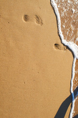 Fototapeta na wymiar Footprints in the sand on the beach