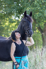 Obraz premium woman and horse / Brunette woman with black horse in forest 