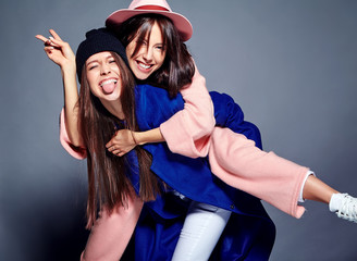 fashion portrait of two smiling brunette women models in summer casual hipster overcoat posing on...