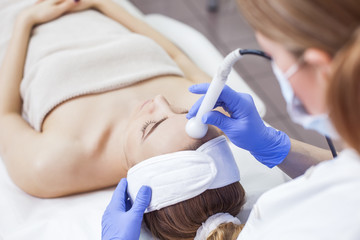 Face skin care. Woman getting facial laser treatment