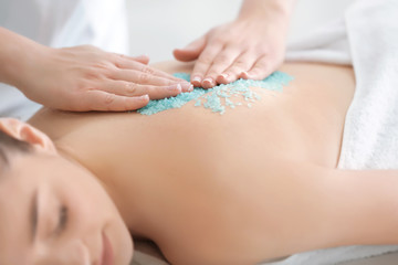 Obraz na płótnie Canvas Beautiful young woman receiving scrub massage in spa salon, closeup