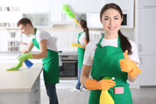 Young female cleaner at work in kitchen
