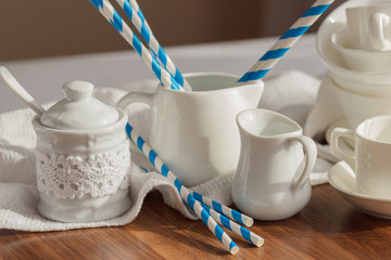 Set of white empty tableware with striped tubules