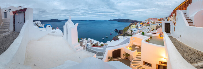 Oia town on Santorini island, Greece. Traditional and famous houses and churches with blue domes over the Caldera, Aegean sea