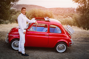 Smiling by his restored vintage car