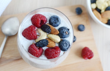 Vitamin breakfast yogurt chia seed cocktail with berries, dried fruits and nuts in glass