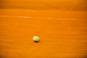 tennis red ball on a clay tennis court orange color