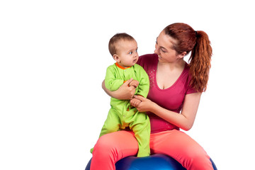 A mother and baby doing gymnastic exercises on the ball. Isolated background