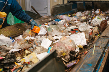 The worker sorts the waste received by a modern plant for sorting and recycling waste. Waste...