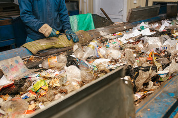 The worker sorts the waste received by a modern plant for sorting and recycling waste. Waste...