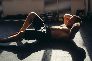 Muscular man exercising doing sit up exercise. Athlete with six pack, white male, no shirt - obrazy, fototapety, plakaty