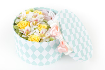 Round box with fresh flowers and meringue cookies isolated on white background